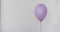 Womans hand holds purple balloon white background