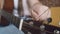 Womans hand tunes an acoustic guitar by pulling string by twisting guitar pegs, closeup. Musician tunes his instrument