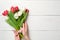 Womans hands holding Bouquet of tulips on white wooden horizontal striped board. Greeting card for International Womans Day, Mothe