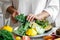 Womans hands lay out fresh vegetables on a plate.