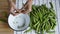 Womans hands opening fresh ripe green pea bean