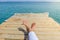 Womans legs on a dock while relaxing on seaside