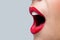 Womans mouth wide open with red lipstick.