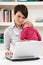 WomanWith Newborn Baby Working From Home