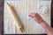 Womanâ€™s hand dropping flour on pastry cloth, wood rolling pin with cloth cover, small bowl of flour
