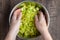 Womanâ€™s hands in a bowl of chopped celery and rainbow carrots, mixing my hand, on a wood table