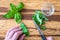 Womanâ€™s hands chopping fresh basil with a paring knife on a rustic grove bamboo cutting board, small glass bowl