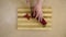 Womanâ€™s hands are cutting sweet red pepper Kapi on the rings on a kitchen board by a metal knife.