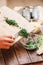 Womanâ€™s hands pours sliced greenery.