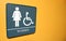 Wome's bathroom sign on orange wall with space for text and handicapped symbol