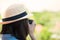 Women asian tourists wearing hat holding a camera.