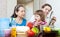 Women with baby girl cook with vegetables