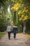 Women back walking in parc with maple trees