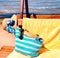 Women beachwear  on wooden bench  hat with blue bow and hand bag and yellow towel  accessory, on horizon sea wave spl