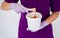 Women beautician holds jar wax of paste for sugar depilation shugaring, white background