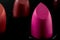 Women beauty products, luxury fashion and makeup concept with macro close up on a row of lipstick tubes in a line on dark