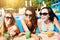 Women with beverages on summer party near the pool