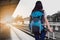 Women, blue backpack and hat at the train station