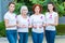 women with breast cancer awareness ribbons holding cubes with word cancer and looking