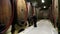 a women checking the barrels in the wine cellar