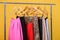 Women colorful skirts on hangers on rack on orange background.