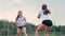 Women competing in a professional beach volleyball tournament. A defender attempts to stop a shot during the 2 women