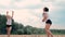 Women competing in a professional beach volleyball tournament. A defender attempts to stop a shot during the 2 women