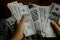 women counting money on a stack of 100 US dollars banknotes