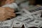 women counting money on a stack of 100 US dollars banknotes a lot of