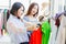 Women customer choosing clothes looking for new shirt in fashion shop with friend happy smile