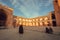 Women in dark muslim dress walking past a historical persian mosque with courtyard