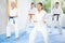 Women of different ages in kimono standing in fight stance during group karate training in gym