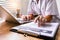 Women doctors sit to write patient reports in the office.