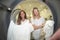 Women doing laundry viewed from inside tumble drier