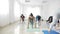 Women doing warrior yoga pose after work in a bright wellness studio in slow motion -