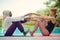 Women doing yoga by the poolside