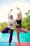 Women doing yoga by the poolside