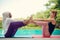 Women doing yoga by the poolside