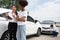 Women drivers Talk to Insurance Agent for examining damaged car and customer checks on the report claim form after an accident.