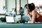 Women and ear phone listen music between workout and relaxing. Laptop, apple, dumbbell and water bottle on the ground beside