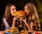 Women eating fast food. Gils eat hamburger with ham .