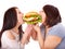 Women eating hamburger.