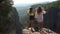 Women enjoy view of distant mountains standing on stone edge