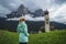 Women enjoy view of St Valentine's Church, Seis am Schlern, Italy. Schlern mountain with rainy clouds in background