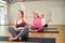 Women exercising during yoga class in fitness center - vakrasana pose