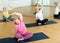 Women exercising during yoga class in fitness center - vakrasana pose