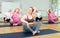 Women exercising during yoga class in fitness center - vakrasana pose