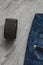 Women fashion clothes and accessories on a wooden background. Brown leather bracelet with rivets and blue jeans.