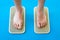 Women feet are standing on a board with sharp nails, Sadhu Board. yoga practice. pain, trial, health. blue yoga mat.