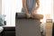 Women is folding grey yoga mat after training yoga at home. Fitness female is holding yoga mat